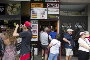 Turistas en uno oficina de cambio de moneda en Sevilla